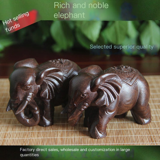 Dark carved elephant figurine with raised trunk and detailed sandalwood-style texture