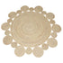 Round natural jute rug with woven texture under a modern chair and side table