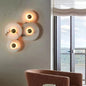 Round marble wall sconce with natural stone texture and soft halo light behind it