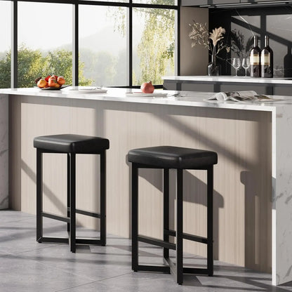 Modern kitchen interior featuring a 24" Bar Stools Set of 2 — Backless Counter Height with PU Leather Seat in black, paired with a light wood breakfast bar and natural sunlight.