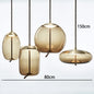 Modern LED Pendant Light — Chandelier for Living & Dining Room featuring four hanging amber glass shades with varied shapes and rope cords, creating a warm, elegant ambiance.