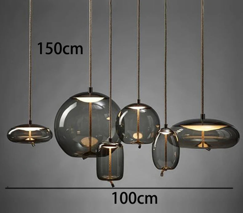 Modern LED Pendant Light — Chandelier for Living & Dining Room featuring six varying smoky glass pendant shades suspended by cords, showcasing minimalist and sculptural pendant lighting.