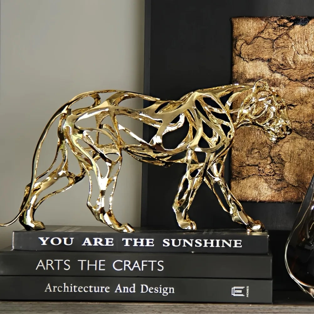 Nordic Metal Leopard Sculpture — Living Room Desktop Home Décor in polished gold tone with an openwork design, displayed as a sculptural accent atop stacked art and design books.