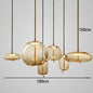 Modern LED Pendant Light — Chandelier for Living & Dining Room featuring six amber glass orbs in varying organic shapes suspended at different heights with gold-toned accents for a warm, sculptural statement lighting.
