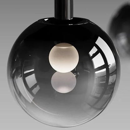 Close-up of a modern glass globe pendant light featuring a white bulb inside, part of the Nordic Stair Chandelier — Living & Dining Room Pendant Ceiling Light, designed for luxury home décor.