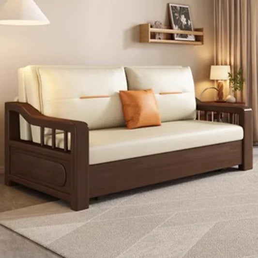 Cream sofa with dark wood arms orange pillow side table lamp and wall shelf