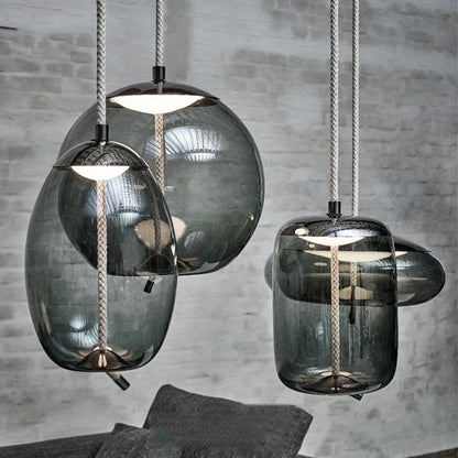 Modern LED Pendant Light — Chandelier for Living & Dining Room with four sculptural smoked glass shades hanging from braided cords against a gray brick wall, showcasing minimalist luxury home décor.