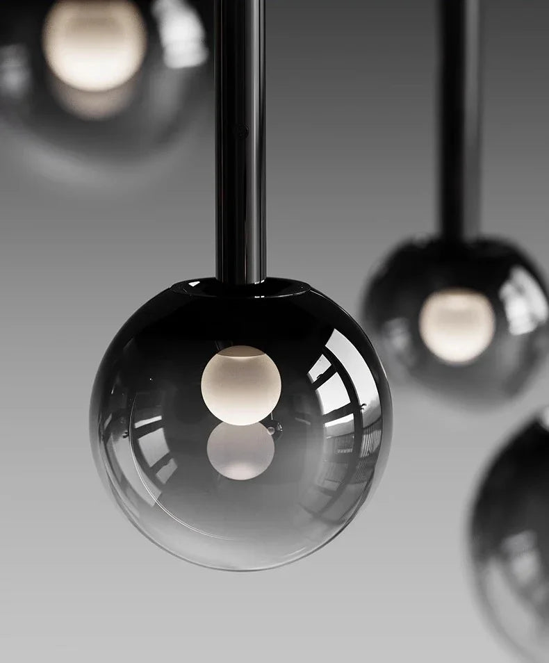 Close-up of a modern glass pendant light with reflective surface and soft white inner bulb, part of the Nordic Stair Chandelier — Living & Dining Room Pendant Ceiling Light.