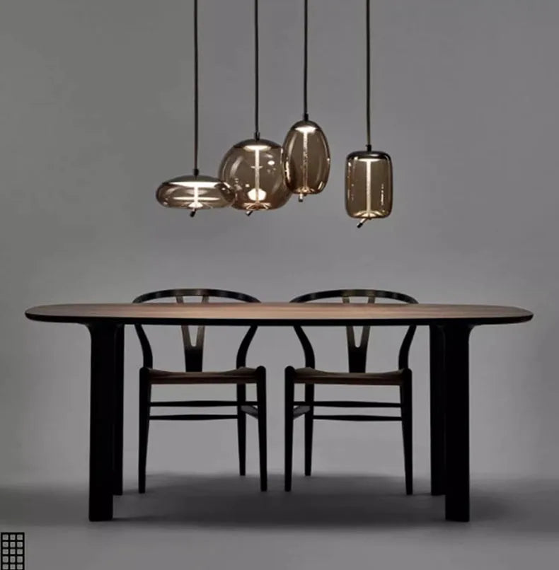 Modern LED Pendant Light — Chandelier for Living & Dining Room featuring four unique smoky glass pendants hanging above a minimalist wooden dining table with two chairs, perfect for luxury home décor.