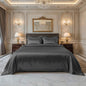 Gray bamboo silk king bedsheet set with smooth fabric draped over a bed