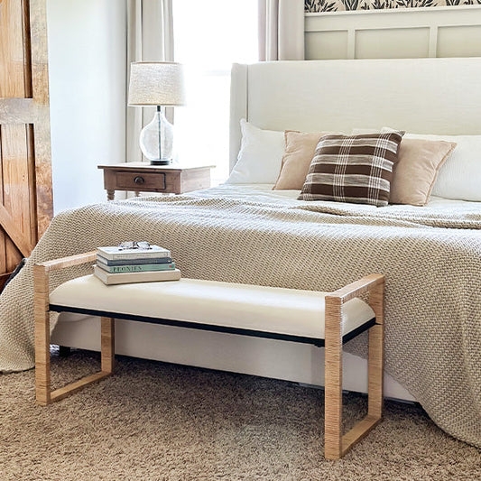 Wooden bench with woven rattan seat and light natural frame on a white background